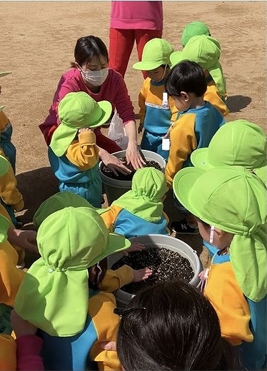 先生が穴を開け、その中にジャガイモを入れました。子ども達はジャガイモが隠れるように土を被せていましたよ。